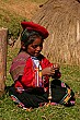 A little girl weaves some thread while posing for all the tourist cameras.